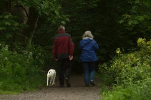 Retired couple walk their dog